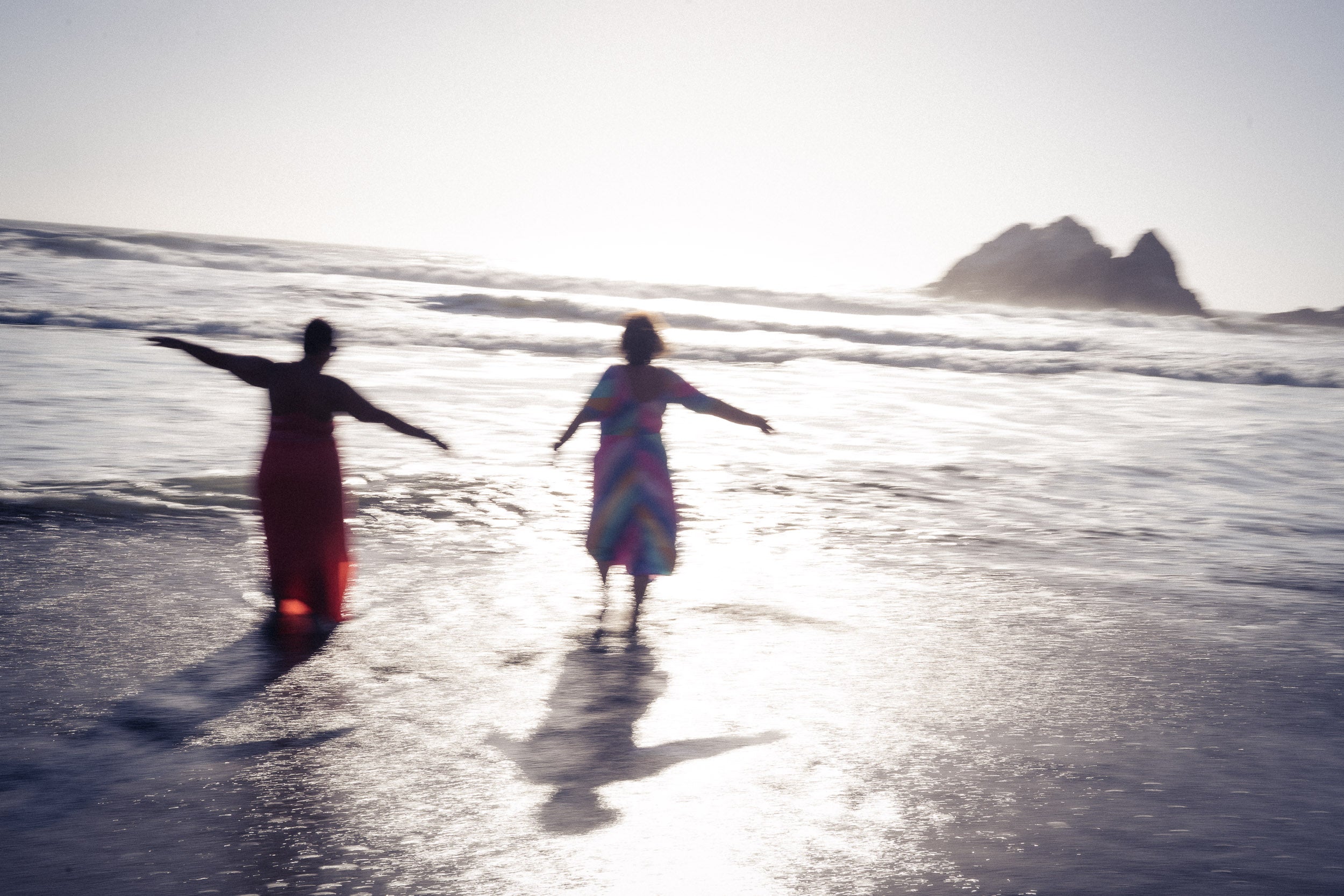 Michelle and Danyelle on the beach at golden hour — homepage hero